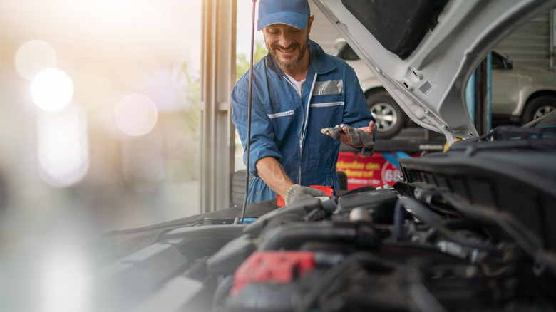 Auto mechanic working under the hood of a car