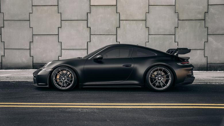 A matte black Porsche sports car parked on road