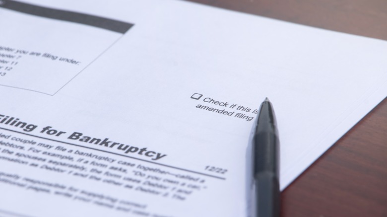 A filing for bankruptcy form with a pen sitting on top