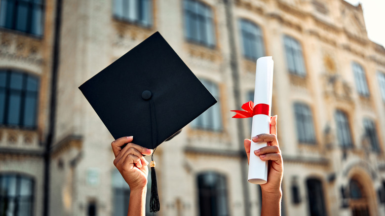 Hands holding up a graduation cap and a diploma