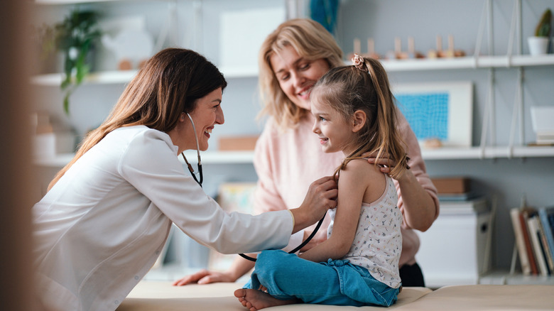 Mother and daughter in doctors office.