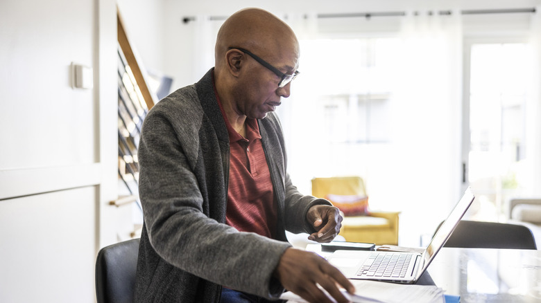 retired man sitting with laptop at table