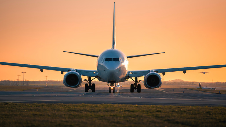 An airplane on the runway at sunset