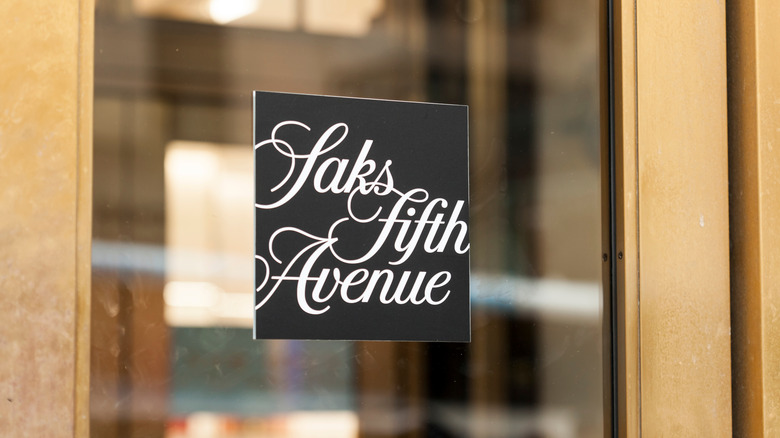 The Saks Fifth Avenue logo on a glass door in a gold frame