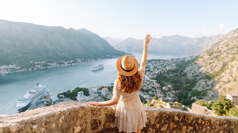Person standing against a backdrop of a sea
