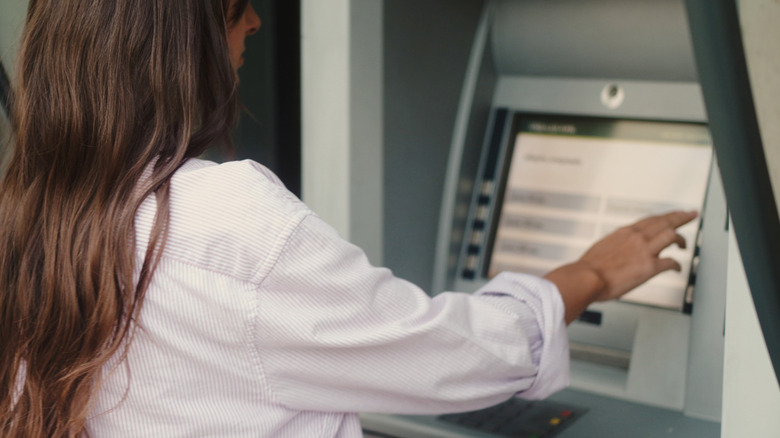 woman checking account balances on an ATM