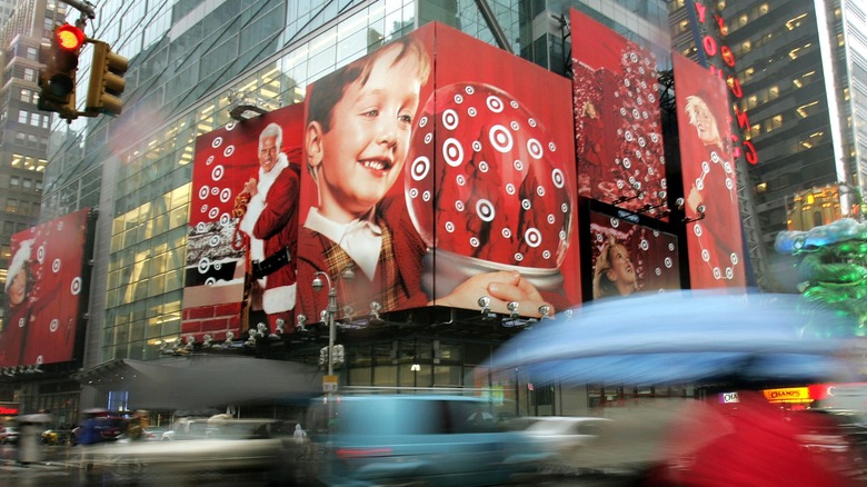 Large red Target holiday billboards featuring Santa Claus and a child with a snow globe above a busy city street
