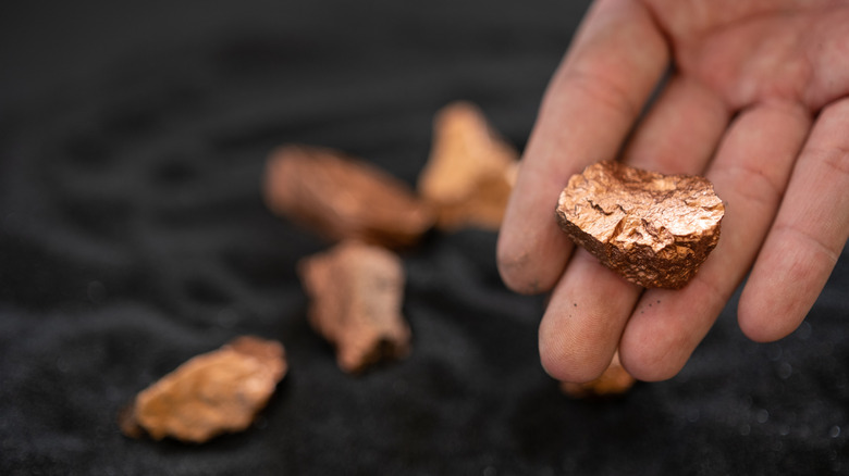 Hand holding a piece of copper