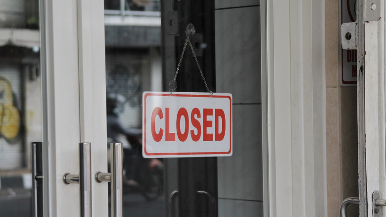 'Closed' sign with white lettering displayed in a storefront window