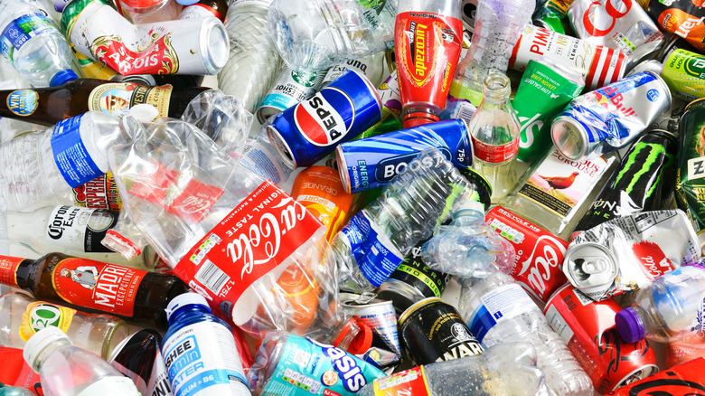 A large, messy mix of bottles and cans meant for recycling