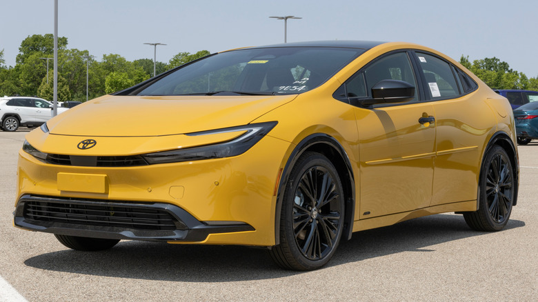 A new yellow Toyota Prius parked outside.