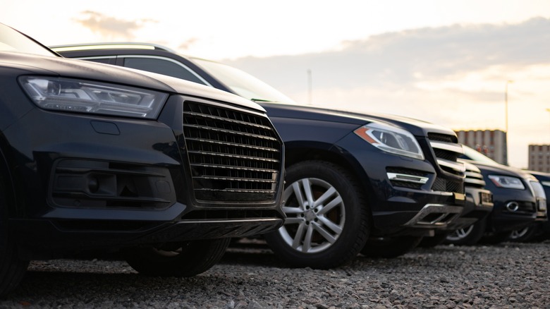 SUVs displayed on a gravel lot.