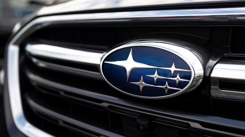 Close-up of the blue-and-silver Subaru emblem mounted on a vehicle's black front grille