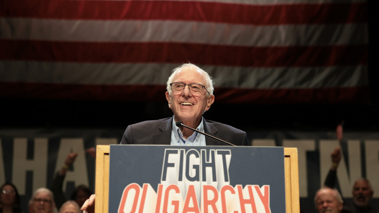 Senator Bernie Sanders on stage with a "Fight Oligarchy" sign on his podium