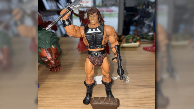 A 2022 edition of MOTU Wun-dar He-Man with a vest on shown from the back.