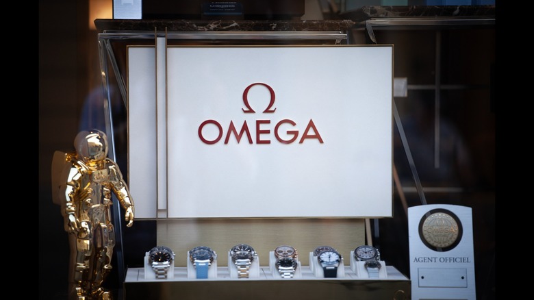 An array of Omega watches arranged in an open briefcase with the Omega logo inside the briefcase lid