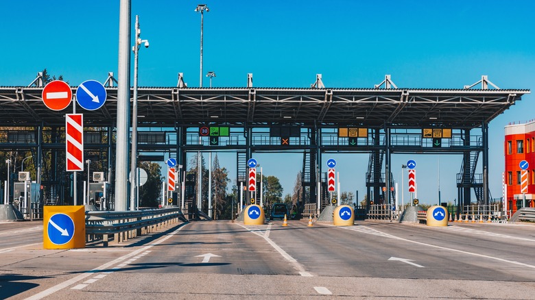 Toll station. Crossing toll road gates at sunny summer day