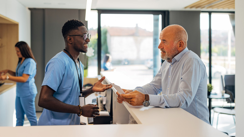 A hospital receptionist discusses billing with a patient