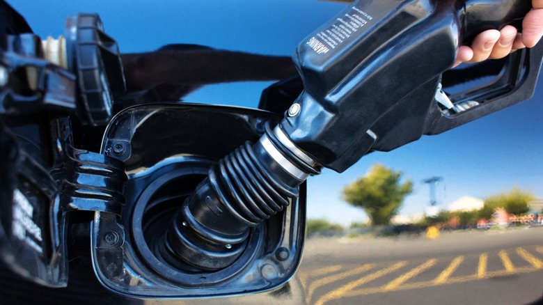 Gas pump nozzle inserted into a car's fuel tank during refueling