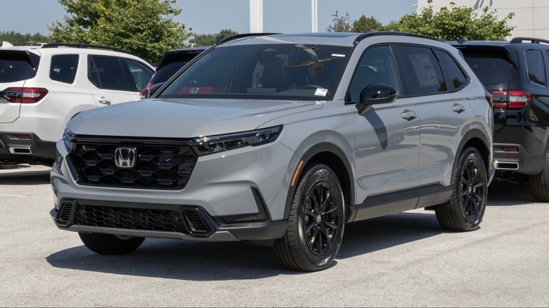 Gray Honda CR-V parked at a dealership lot, shown from the front side with other SUVs in the background