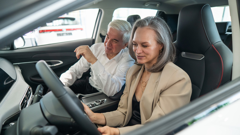An older couple looking at a car in a dealership