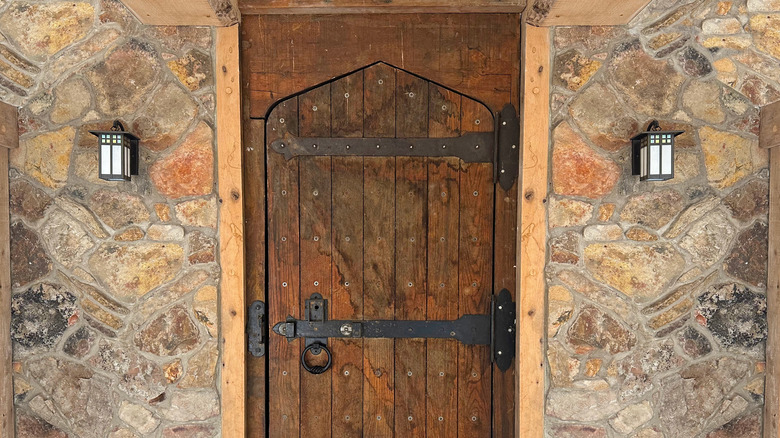 Heavy wooden antique door with black metal hardware