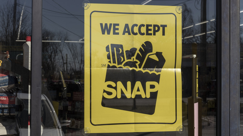 a yellow SNAP poster in the window of a grocery store