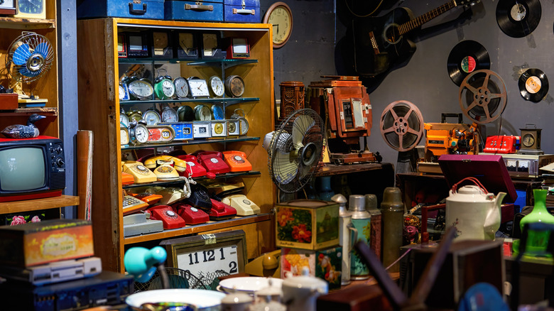 Crowded thrift shop with clocks, phones, and more
