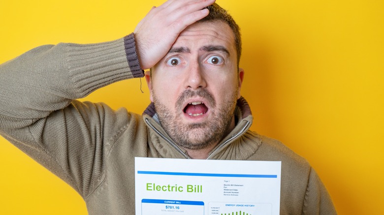 person shocked by expensive electric bill