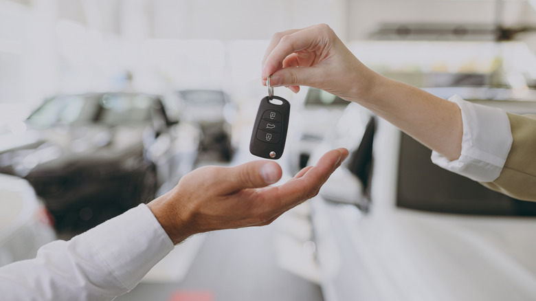 handing keys to a car dealer
