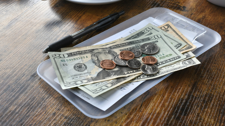 paper money, coins, and a check on a table