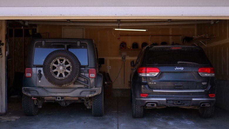 A Jeep Wrangler and Grand Cherokee in a garage