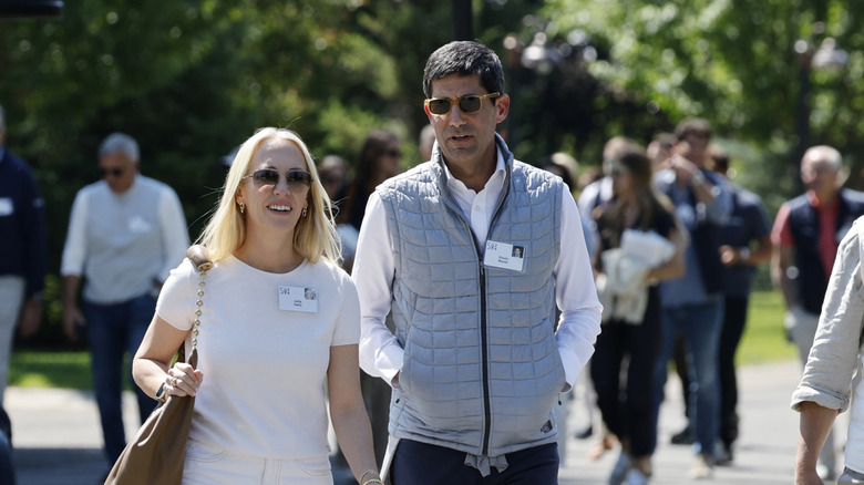 Kevin Warsh walking outdoors with a woman next to him.