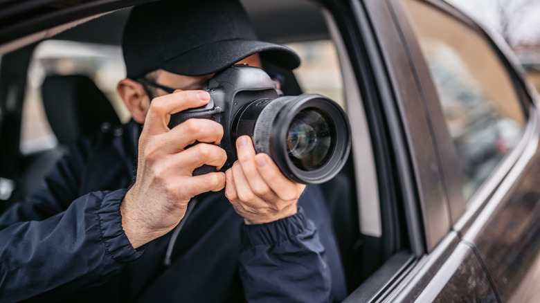 Man taking a picture of someone from a car