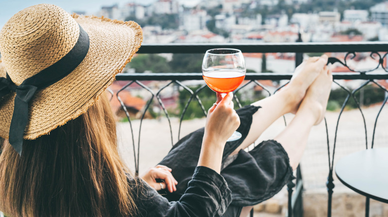 Wealthy woman having a drink with her feet up during a luxurious vacation
