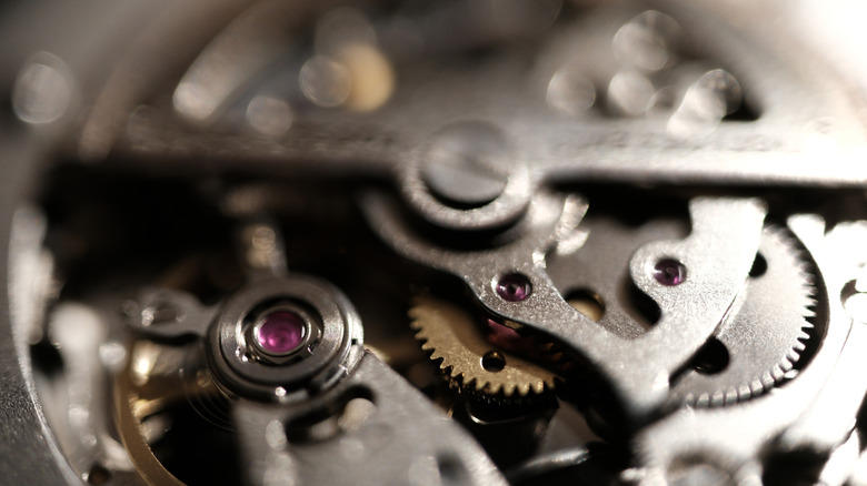 A close-up shot of the gears and mechanical elements of a timepiece.