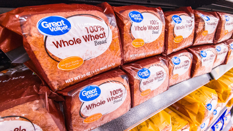 A close-up of Great Value 100% whole wheat bread on a shelf.