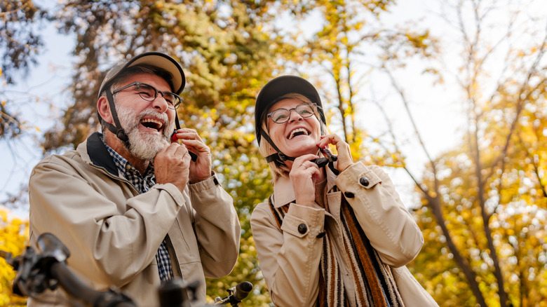 older couple fastening their bike helmets