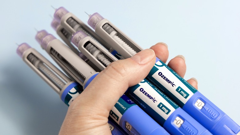 Hands holds many Ozempic syringe pen with needle