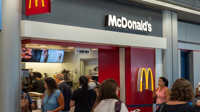 Customers gather at a McDonald's counter in a busy food court