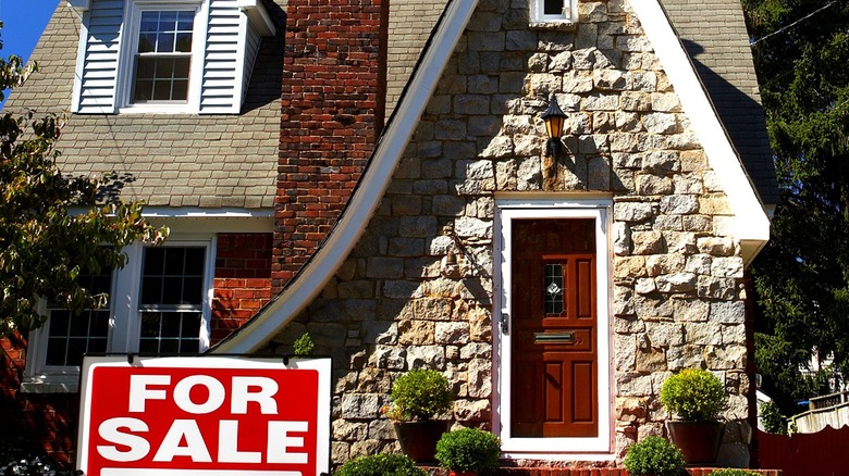 Miniature house surrounded by money