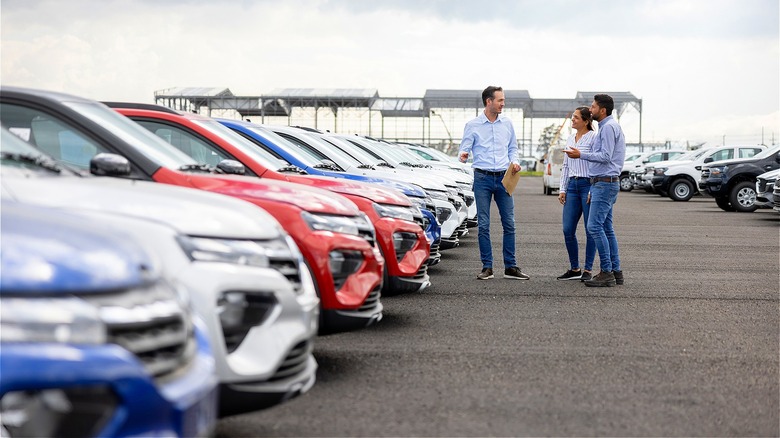 Customers discussing cars at dealership