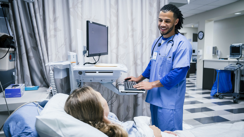 Medical professional speaking with patient while at computer