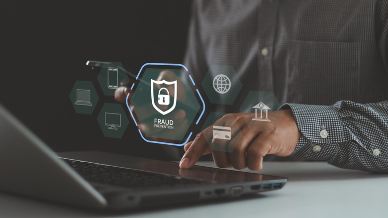 Man using a laptop with a fraud prevention symbol