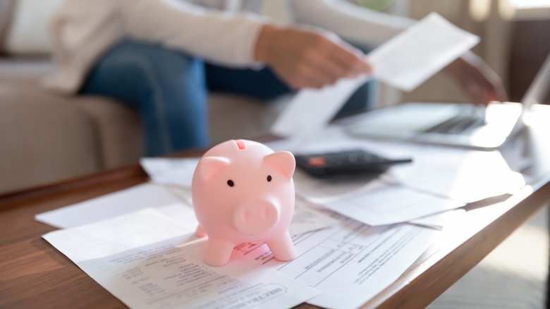 Person, paperwork and piggy bank