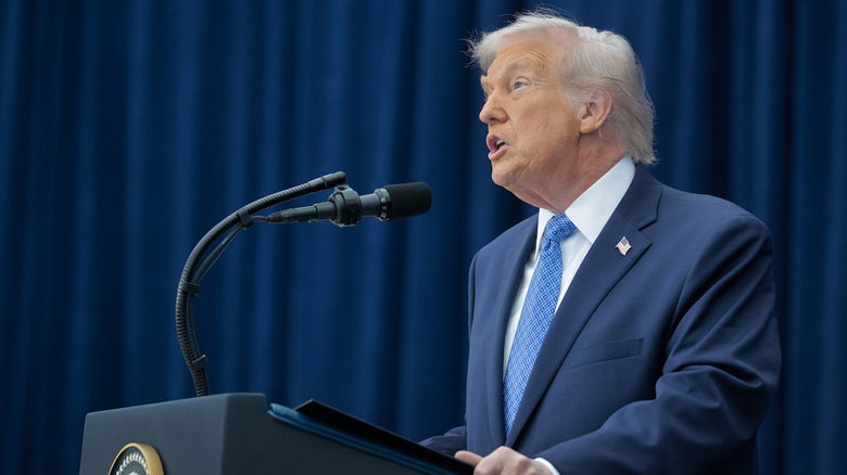 President Donald Trump speaking at a podium.