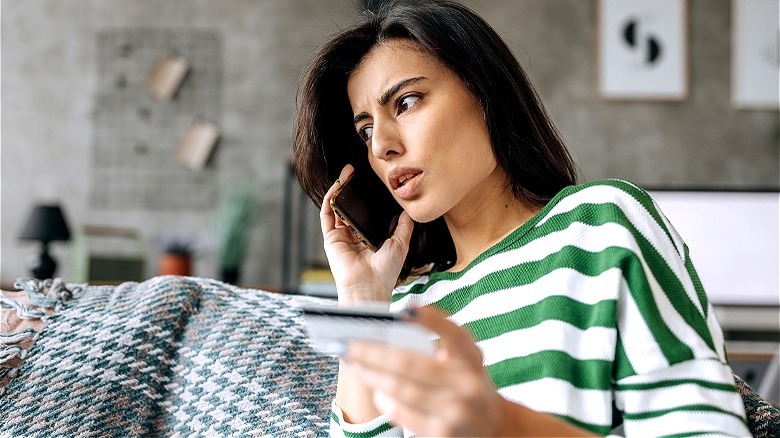 Person on phone, holding card