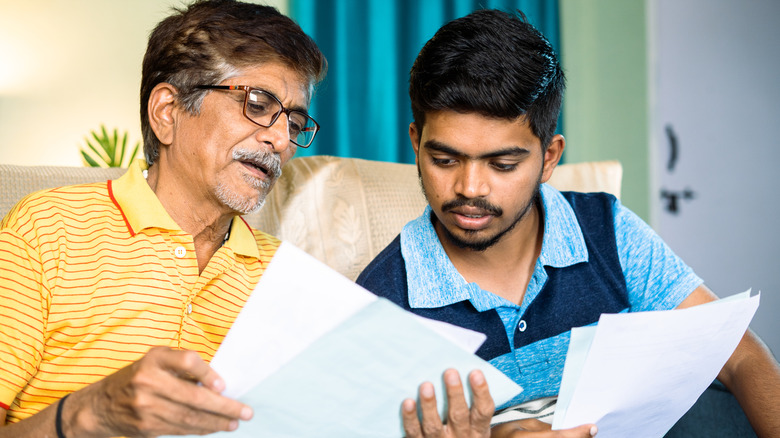 older and younger family members looking at paper together