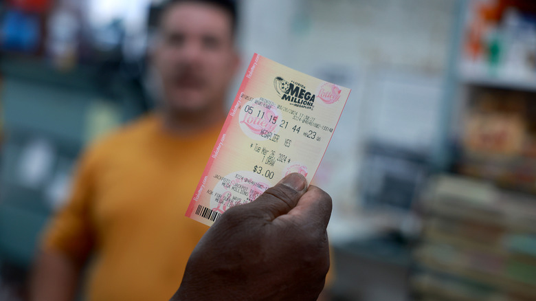 A customer purchases a Mega Million lottery ticket at the La Esquina Tropical supermarket