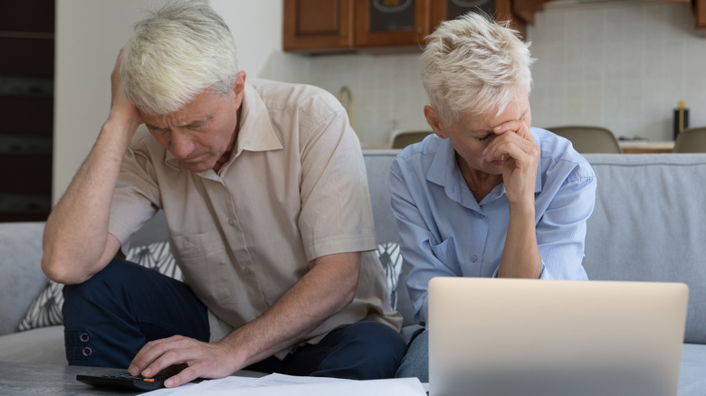 Old couple looking at laptop with dismay